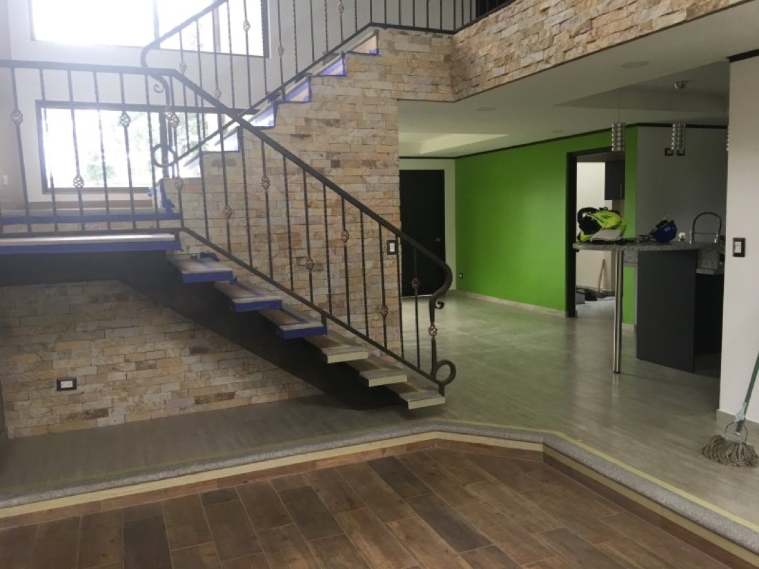 Acabados interiores: escalera con baranda de forja y piso de madera