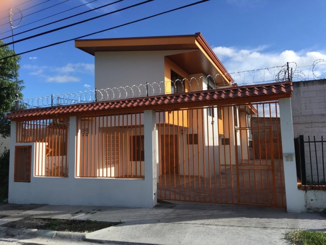 Casa con portón y verja de metal color cobre